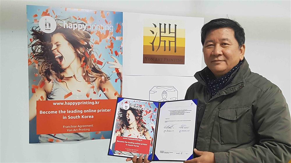 De heer K.S. Kim, COO van Yon Art Printing, met het getekende Happyprinting franchise-contract